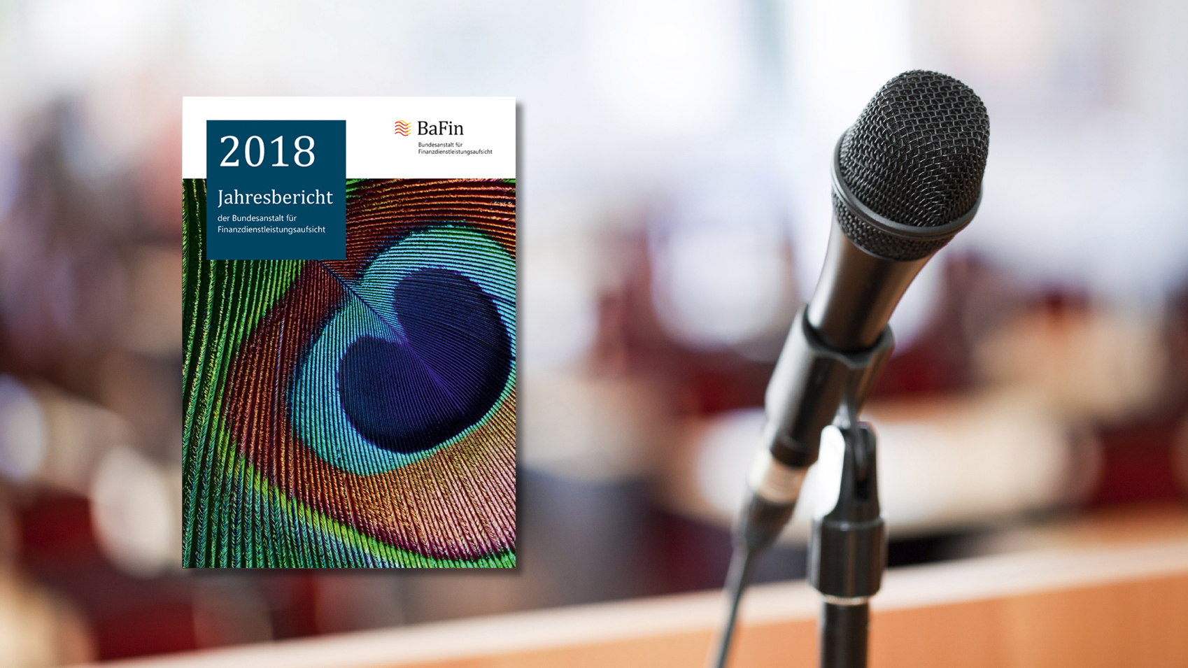 Das Bild zeigt im Vordergrund das Cover des aktuellen BaFin-Jahresberichts 2018 und als Symbolfoto für die Jahrespressekonferenz 2019 ein im Ständer befindliches Mikrofon vor einem unscharf abgebildeten Raum.
